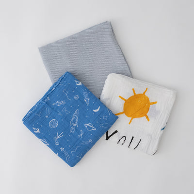 3 swaddle blankets featuring grey micro stripe, white background yellow sun and blue stars, and blue background with white space items