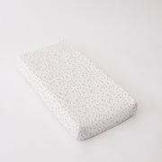 cotton muslin changing pad cover with pink cherry blossom petals on a white background