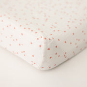 cotton muslin changing pad cover with pink cherry blossom petals on a white background