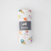 single swaddle blanket with ice cream cones, banana splits, and other frozen treats rolled in Red Rover packaging