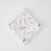 single swaddle blanket with blue, red, and grey paper planes on a white background
