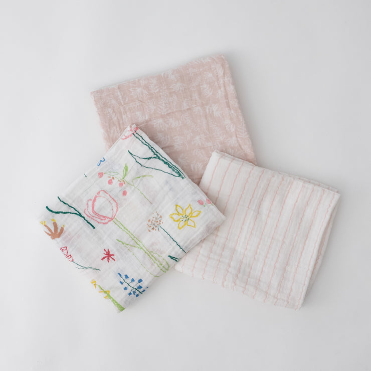 3 swaddle blankets featuring a flower, pink stripe, and pink background with white flowers print