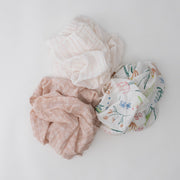 3 swaddle blankets featuring a flower, pink stripe, and pink background with white flowers print