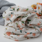 3 swaddle blankets focusing on the peach blossom print with pink flowers and white background