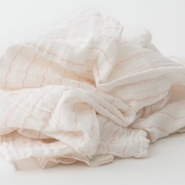 single swaddle blanket with pink crossed stripes on a white background
