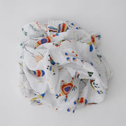 single swaddle blanket with party items including balloons, pinatas, party hats, confetti, and cake 