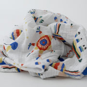 single swaddle blanket with party items including balloons, pinatas, party hats, confetti, and cake 
