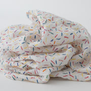single swaddle blanket with lots of different colored sprinkles on a white background