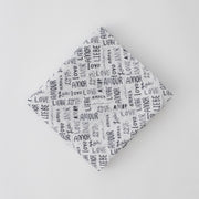 single swaddle blanket with the word "love" in multiple different languages in grey writing