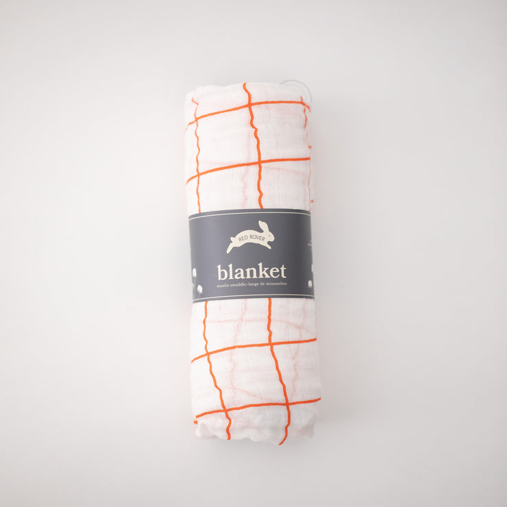 single swaddle blanket with orange crossed stripes rolled in Red Rover packaging