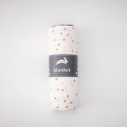 single swaddle blanket with pink cherry blossom petals rolled in Red Rover packaging