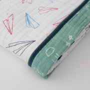 super soft cotton muslin quilt with paper airplanes on one side and a chalk board style print on the other side