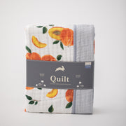 super soft cotton muslin quilt with whole and cut open peaches on one side and grey micro stripes on the other side in Red Rover packaging