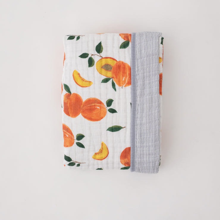 super soft cotton muslin quilt with whole and cut open peaches on one side and grey micro stripes on the other side