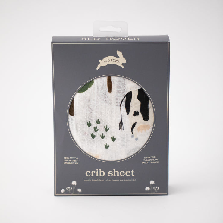 cotton muslin crib sheet with farm animals including cows, chickens, goats, sheep, and pigs in Red Rover packaging