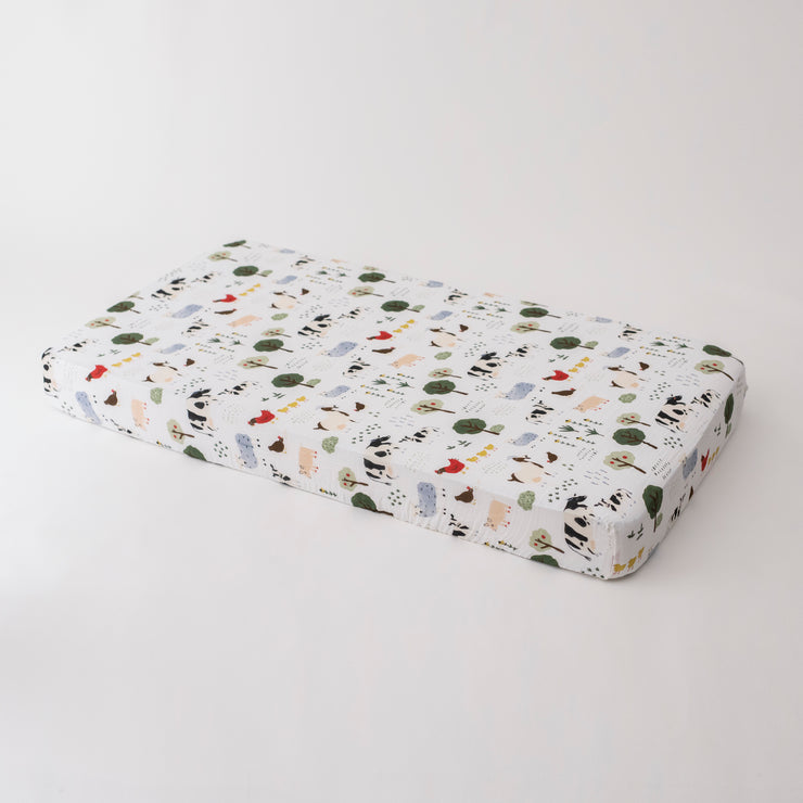 cotton muslin crib sheet with farm animals including cows, chickens, goats, sheep, and pigs