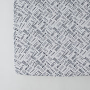 cotton muslin crib sheet with the word "love" in multiple different languages in grey writing on a white background
